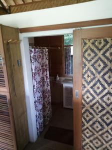 y baño con cortina de ducha y lavamanos. en Babahan Farmstay, en Tabanan