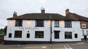 um edifício branco na esquina de uma rua em Chequers Inn em Battle