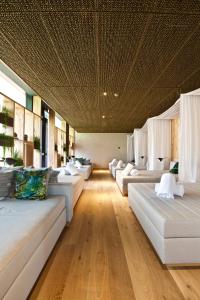 a living room with white couches and a ceiling at The Hide Flims Hotel a member of DESIGN HOTELS in Flims