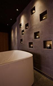 a bath room with a tub and a mirror at The Hide Flims Hotel in Flims