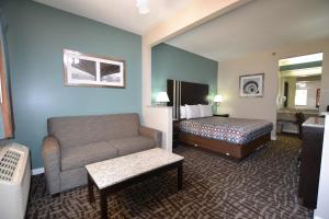 a hotel room with a couch and a bed at Relax Inn Motel and Suites Omaha in Omaha