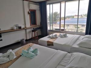 Postel nebo postele na pokoji v ubytování Pimpimarn Hotel