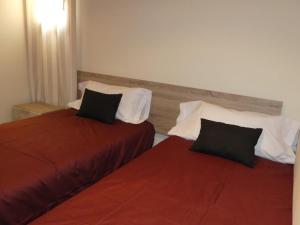 two beds sitting next to each other in a room at DÚPLEX Acollidor al Centre de Vic APTGARBI in Vic