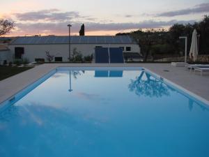 a large blue swimming pool in front of a building at Kinanto Bioresort in Ispica