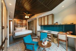 a bedroom with a bed and a desk and chairs at Minh Boutique in Danang