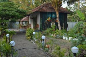 una casa con un jardín delante de ella en Nettle Trees Farm Stay, en Alleppey