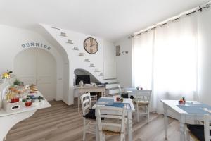 a dining room with tables and a clock on the wall at B&B Sunrise in Santa Marina Salina