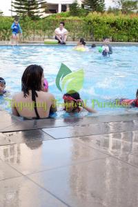 PS4+NETFLIX+TV PLUS Tagaytay Tropical Staycation at SMDC في تاجيتاي: وجود مجموعة أشخاص في المسبح