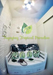 a bedroom with a bed with green and white pillows at PS4+NETFLIX+TV PLUS Tagaytay Tropical Staycation at SMDC in Tagaytay