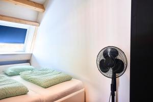 a room with a fan next to a bed at ROYAAL APPARTEMENT CENTRUM MIDDELBURG in Middelburg
