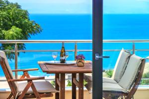 een tafel met twee stoelen en wijnglazen op een balkon bij Aphrodite of Thassos in Skala Marion
