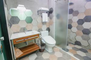 uma casa de banho com um WC, um lavatório e um chuveiro em The Leaf Inn em Hualien