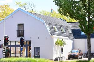 a white house with a car parked in front of it at ROYAAL APPARTEMENT CENTRUM MIDDELBURG in Middelburg
