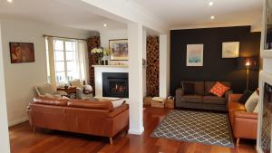 a living room with two couches and a fireplace at Bowral Escape in Burradoo