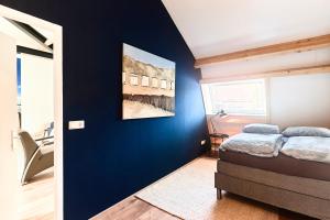 a bedroom with a blue wall with a bed at RIANT APPARTEMENT CENTRUM MIDDELBURG in Middelburg