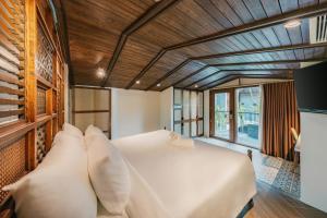 a bedroom with a large white bed with pillows at Minh Boutique in Danang