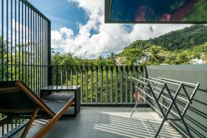 a balcony with chairs and a view of a mountain at The Deck Condominium by Lofty in Patong Beach