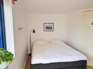 een kleine slaapkamer met een bed met witte lakens bij Gårdshotellet in Ystad