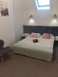 um quarto com uma cama grande e uma cadeira em Domek 87 em Krynica-Zdrój