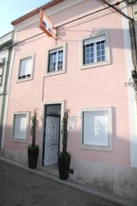 Casa rosa con puerta y ventanas en Alojamento S. João, en Peniche