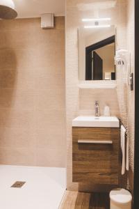 een badkamer met een wastafel, een toilet en een spiegel bij Hôtel Hors-Château - Liège Centre Historique in Luik