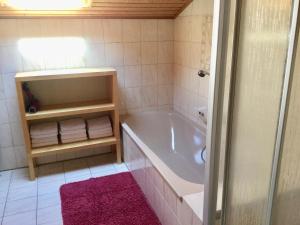 ein Badezimmer mit einer Badewanne und einem rosa Teppich in der Unterkunft Ferienwohnung Doris Strodl in Füssen