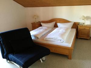 um quarto com uma cama de madeira e uma cadeira em Ferienwohnung Doris Strodl em Füssen