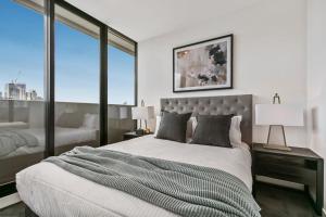 A bed or beds in a room at Sweeping CBD views – Luxury 2BR 2BA apartment with free wine, Netflix and roof spa!