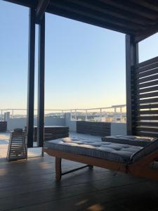 a bed on a balcony with a view of the city at MV83 new marina in Rhodes Town