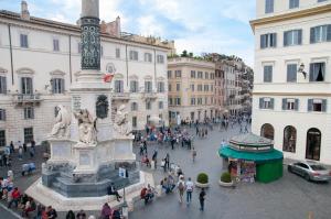 un grupo de personas de pie alrededor de una estatua en una calle en Hotel Scalinata Di Spagna, en Roma