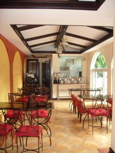 a dining room with tables and chairs and a kitchen at The Suites at Calle Nueva in Bacolod