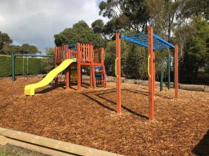 a playground with a slide in a park at Prom Coast Holiday Lodge in Waratah Bay