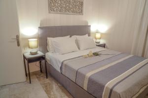 a bedroom with a large bed with two lamps at Arkadins in Zakynthos