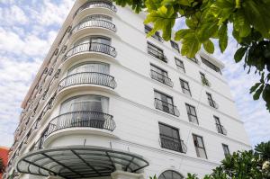 a white building with balconies on the side of it at SAIGON GARDEN HILL Resort & Apartment in Ho Chi Minh City