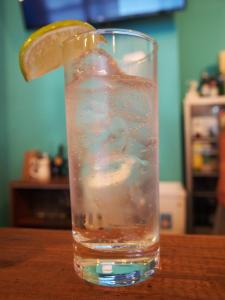 a glass of water with a lemon slice in it at Mad Cat Hostel Osaka & Bar in Osaka