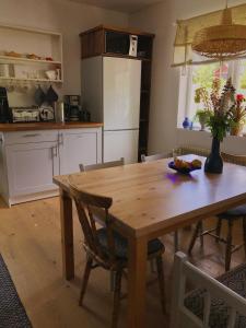 a kitchen with a wooden table and a dining room at Dala Cottage in Ulriksberg