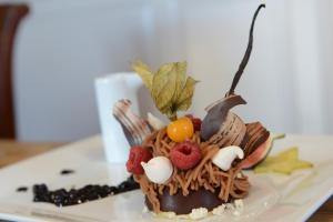 a chocolate dessert with fruit on top on a plate at Hôtel Panorama in Munster