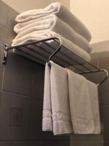 un grupo de toallas colgando de un toallero en el baño en B&B La Ruota Milano, en San Giuliano Milanese