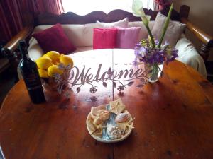 drewniany stół z butelką wina i kwiatami w obiekcie Elena's apartments w mieście Batsi