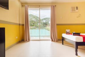 una camera con un letto e una grande finestra di RedDoorz Premium @ Gabinete Road Palawan a Città di Puerto Princesa