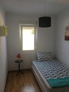 sypialnia z łóżkiem i oknem w obiekcie Apartamento Alcobaca w mieście Alcobaça