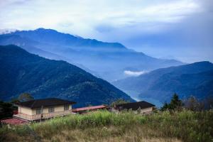 une maison sur une colline avec des montagnes en arrière-plan dans l'établissement Shangrila Music Villa, à Renai