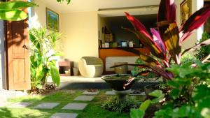 un jardín con plantas y una sala de estar. en Kubu Green en Nusa Dua