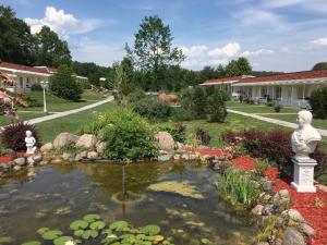 a garden with a pond with a statue in it at Ferienpark-Canow in Canow