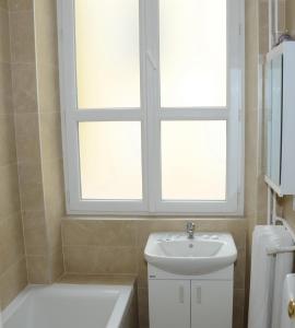 a bathroom with a sink and a window above a toilet at Apartement GT in Nice