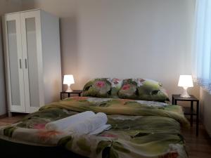 a bed with two lamps and two towels on it at Dom nad Jeziorem in Mucharz