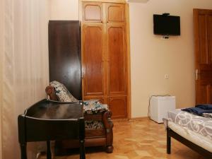 Habitación con silla, TV y cama en Two Towers Guest House, en Kutaisi