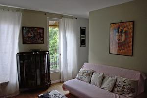 - un salon avec un canapé rose et une fenêtre dans l'établissement 25 Rue du Télégraphe, à Paris