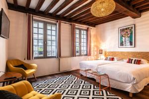 - une chambre avec deux lits, un canapé et une chaise dans l'établissement Hotel Le Port Neuf, à Bayonne