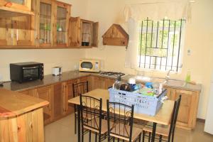 una cocina con armarios de madera y una mesa con sillas. en Egret Cove, en Balaclava